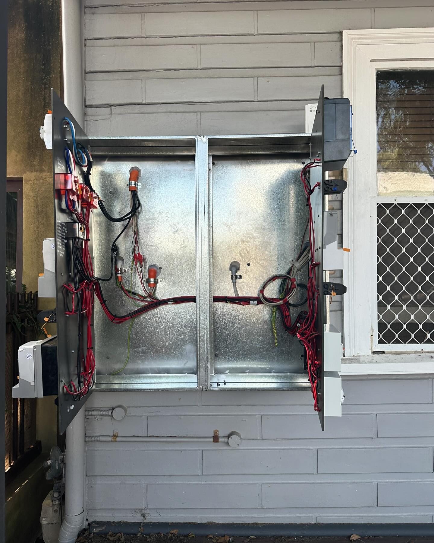A newly installed switchboard and meter panel with tidy wiring on a galvanised backing board